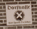 Schild neben der Eingangstür des Hauses Hermann Gerdes: Dorfkasse - Hier sparst du sicher