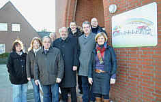 Gemeinsam brachten Vertreter der Lehrer, Eltern, Gemeinden und des Fördervereins das neue Logo am Eingang des Schulgebäudes in Renkenberge an. Foto: Willy Rave/Ems-Zeitung vom 07.12.2010