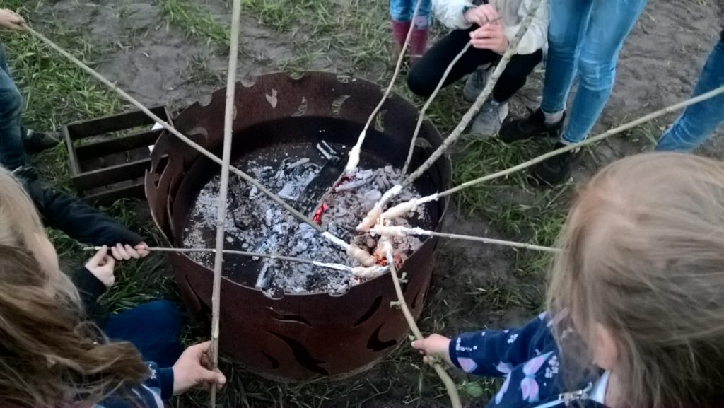 Kinder beim Stockbrotbacken.