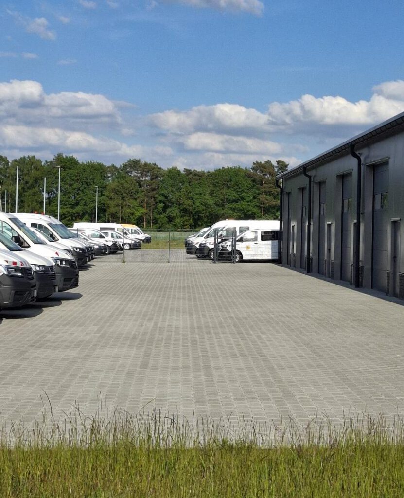 Platz vor der Halle des Gewerbebetriebs mit Fahrzeugen